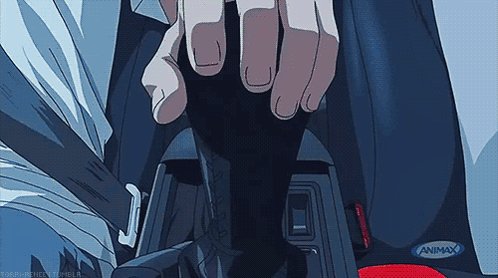 The image shows a person's hand holding down a car gear shift, with their fingers pressing against the buttons. There are two red buttons visible near the center of the image. The background appears to be a car dashboard or steering wheel, which is part of the car's interior.