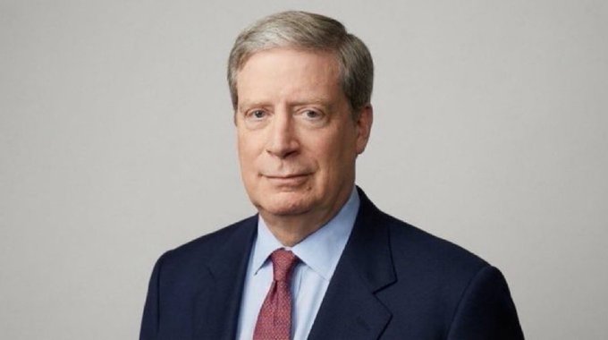 A professional headshot shows a middle-aged man with graying hair, wearing a dark navy suit, light blue dress shirt, and burgundy patterned tie, posed against a light gray background. The polished, corporate-style portrait suggests this is a business or financial figure whose bullish outlook on Ethereum ($ETH) frames the post's message about crypto investment potential.