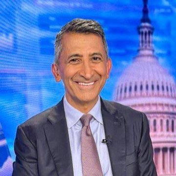 The image shows a smiling man with graying dark hair wearing a gray suit, white shirt, and pink patterned tie, appearing on what looks like a CNBC set with the U.S. Capitol building visible in the background. Based on the accompanying post, this is Faryar Shirzad, Coinbase's policy chief, who expressed disappointment over the failure of the Clarity Act to pass Congress, urging stakeholders to finish the job of establishing clear digital asset regulations by September rather than waiting on legislative action.