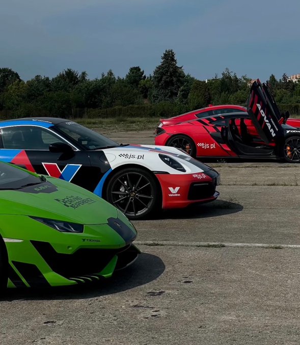Three sports cars—a green Lamborghini, a black and white/red Corvette, and a red McLaren with butterfly doors open—are parked on asphalt with trees in the background, featuring 'js.pl' branding.