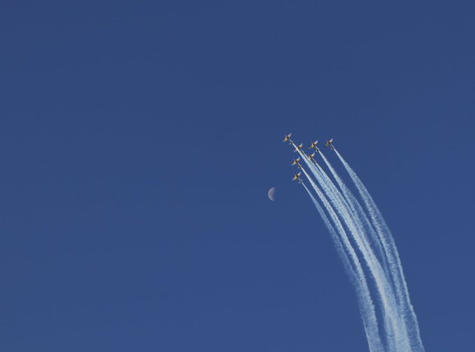 Five aircraft flying in formation with smoke trails ascend past a crescent moon against a deep blue sky, complementing the post's message about personal limits and aspirations—visualizing the freedom of charting one's own soaring path.