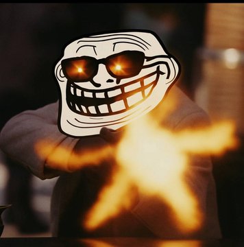 A person wearing a hooded sweatshirt with a glowing troll face meme (featuring sunglasses and a wide grin) is shown with flames erupting in the foreground.