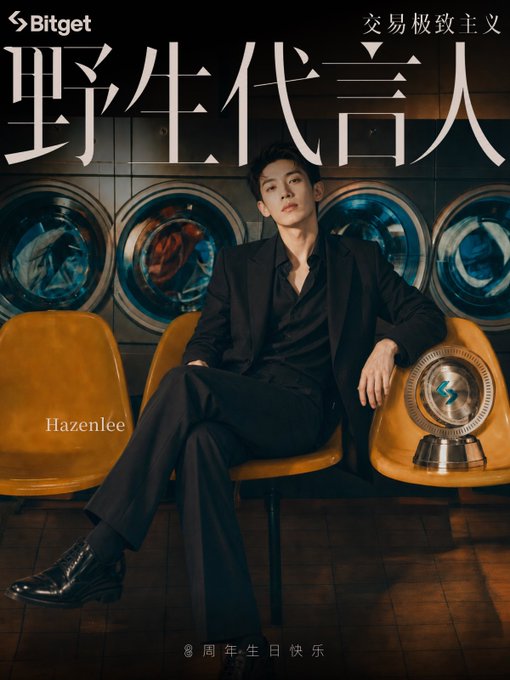 A man in a black suit poses in a laundromat-themed Bitget ad featuring washing machines, yellow chairs, and a trophy, with text reading "Bitget," "交易极致主义" (Trading Extremism), "野生代言人" (Wild Spokesperson), "Hazenlee," and "8 周年生日快乐" (Happy 8th Anniversary). The post celebrates Bitget's 8th anniversary, matching the celebratory theme in the image.