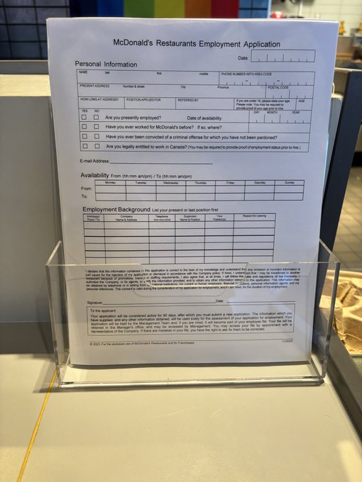 A McDonald's Restaurants Employment Application form displayed in a clear plastic holder on a counter.