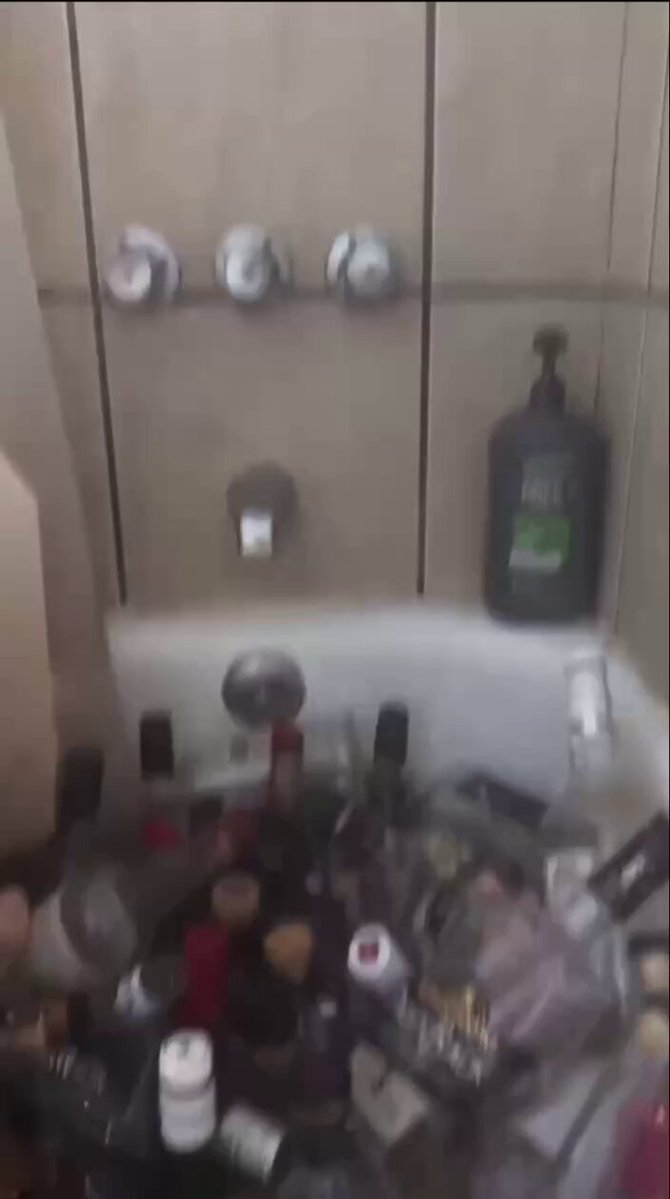 The image shows a bathroom sink filled with various items, including bottles of shampoo, conditioner, and other personal care products. The sink also contains several empty wine bottles, suggesting that someone has been using the space as a makeshift storage area for their belongings. A bottle of liquid soap is visible on the right side of the sink.

The image includes text that reads "Lost it all Crypto is one big scam If sol drops another dollar I am liquidated". This message seems to be related to the items in the bathroom, possibly indicating a scheme or a situation where someone has lost their money and is now trying to recover it by using cryptocurrency.