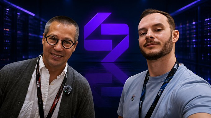 Two men pose for a photo in front of a purple "Blockhash" podcast logo, with the older man on the left wearing glasses and a gray cardigan, and the younger man on the right wearing a light blue shirt. The image accompanies a post about STBL CCO R.J. Vollono's appearance on the Blockhash podcast to discuss STBL's YLD/USST stablecoin structure.