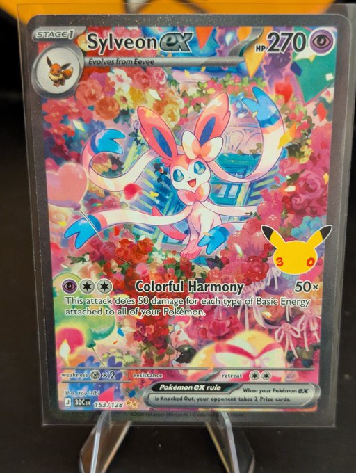 A holographic Pokémon trading card featuring Sylveon ex, a Stage 1 Psychic-type Pokémon with 270 HP, showcasing its 'Colorful Harmony' attack on a floral background.