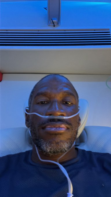 A man with a nasal cannula lies in a hospital bed under blue ambient lighting, suggesting he is receiving medical treatment. The "$MSTR" context suggests the image may be used metaphorically to represent a prolonged recovery or resilience, possibly referencing MicroStrategy stock's extended bear market.