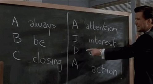 The image features a man dressed in a suit, pointing at a blackboard with white chalk writing about leadership strategies. The text on the board reads "A-B-C @Algorand leadership! Always be closing!". This suggests that the man is discussing the importance of being open and adaptable as leaders, which can be applied to various aspects of life or business.
