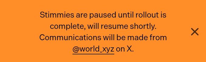 An orange notification banner reads, "Stimmies are paused until rollout is complete, will resume shortly. Communications will be made from @world_xyz on X," with a close button on the right. The image directly conveys the post's announcement that "stimmies" are temporarily halted, linking users to the official @world_xyz account for further updates.