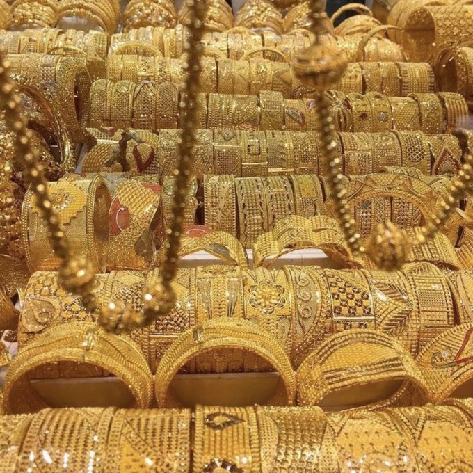 An extensive collection of ornate gold bangles and intricate beaded gold necklaces, likely from a jewelry market in the Middle East.