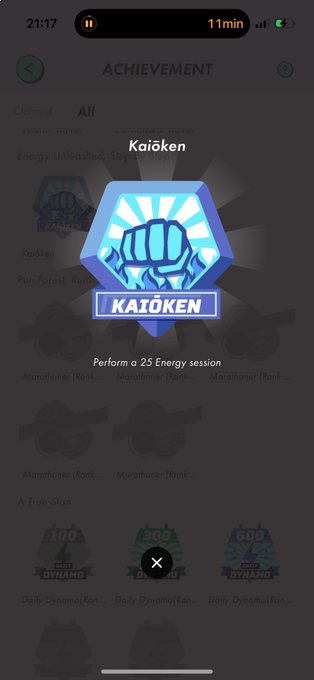 The image shows a phone screen with a blue achievement badge for Kakien, which has been earned by completing an energy efficiency course. The badge is displayed prominently at the top of the screen, indicating that the user has achieved this accomplishment. There are several other achievements and badges on the screen as well, suggesting that the user may have completed multiple courses or tasks to earn these awards.