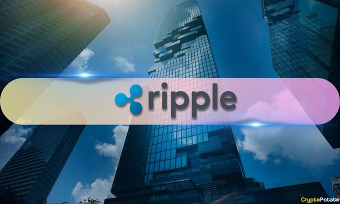 The image displays the Ripple logo prominently against a backdrop of modern skyscrapers under a blue sky, with "CryptoPotato" credited in the bottom right corner. It visually represents Ripple's expansion into prime brokerage services, symbolized by the corporate urban setting that aligns with the announcement of Ripple Prime's new Delta One business for institutional clients.