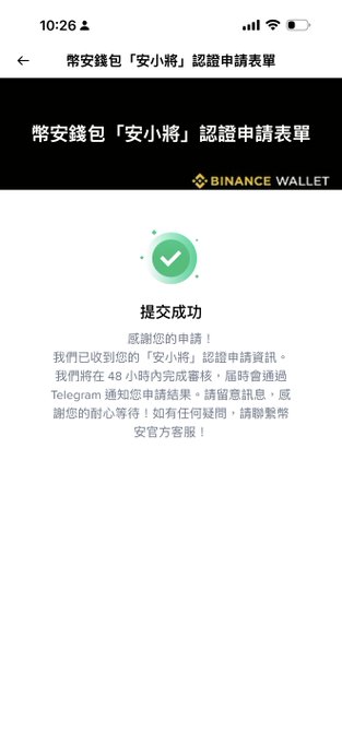 The image shows a phone screen displaying an app called "Binance Wallet" with a green checkmark, indicating that the user has successfully completed the registration process for the wallet. The background of the image is white, which makes the green checkmark stand out prominently against it.