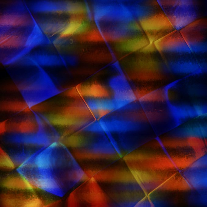 An abstract iridescent pattern featuring a diamond/grid texture with shimmering rainbow colors blending blue, red, yellow, and green hues.