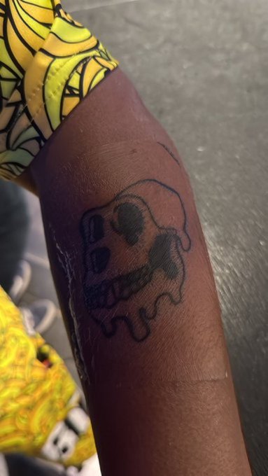 A fresh black ink tattoo of a skull on someone's arm, serving as a permanent mark of their identity as a Mutant Ape member of the exclusive online club community.