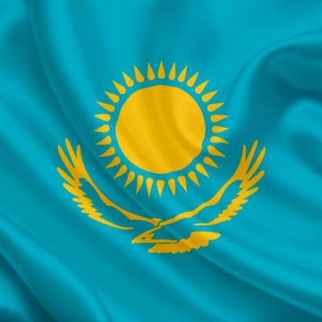 The image shows Kazakhstan’s national flag, featuring a golden sun and eagle on a blue field. It accompanies a report that the AIFC Court restricted Coinbase, HTX, BingX, BitMart, Bitcoincom, and WEEX from offering unlicensed crypto services in Kazakhstan.