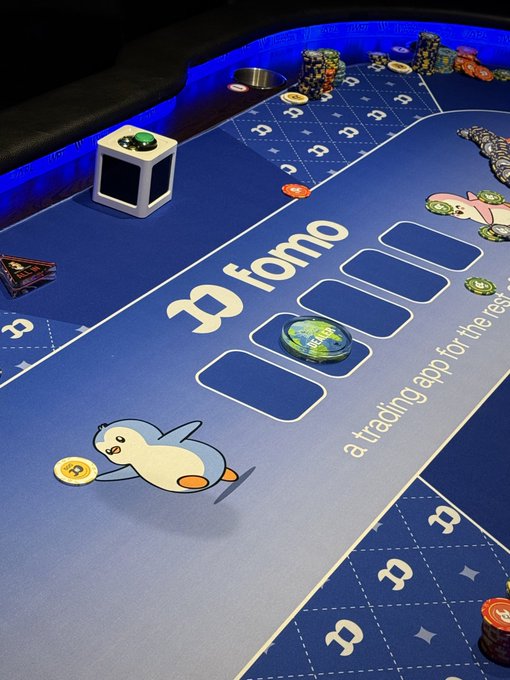 A blue-themed 'fomo' trading table featuring a penguin mascot, poker chips, and text reading 'a trading app for the rest of us.'