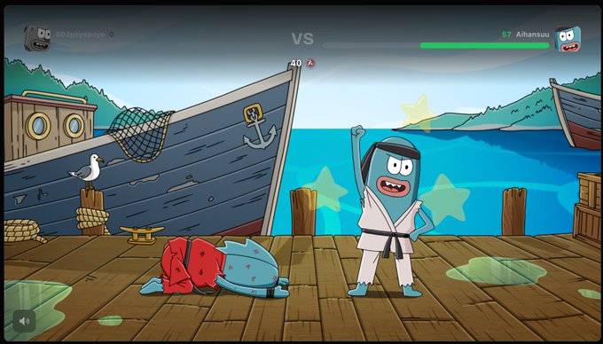 A screenshot of a 2D fighting game on a dock, showing a blue fish-like character in a karate outfit winning against a defeated red character.