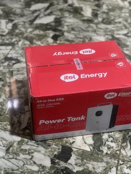 The image shows a red box for an "itel Energy" Power Tank All-in-One ERS with a 100,000 mAh capacity, placed on a speckled granite surface. This relates to the celebratory post about acquiring the itel Power Tank, likely as a gift or self-purchase praised as honest work in the Web3 space.