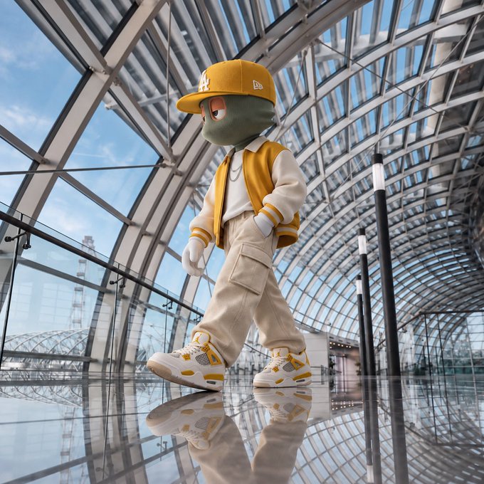 A character wearing a yellow New York Yankees cap, a yellow and white jacket, cargo pants, and sneakers walks through a glass-walled corridor with a reflective floor.