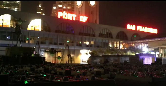 A nighttime view of the Port of San Francisco building with its illuminated red signage visible above the waterfront area.