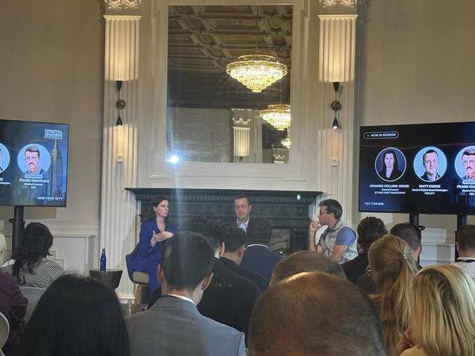 A panel discussion takes place at the Digital Chamber's Convergence Forum, with moderator Frank Dowd and speakers Johanna Calabria-Hoog (Fidelity), Matt Hougan (Bitwise), and Ryan Rasmussen (Bitwise) featured on screens as they discuss the impact of ETFs on crypto capital markets to an engaged audience.