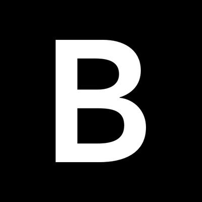 The image shows a large white letter "B" on a black background, which is the iconic Bitcoin logo. It visually represents the digital currency referenced in the caption about Bloomberg's warning of a potential Bitcoin crash toward $10,000 amid a broader stock market decline.