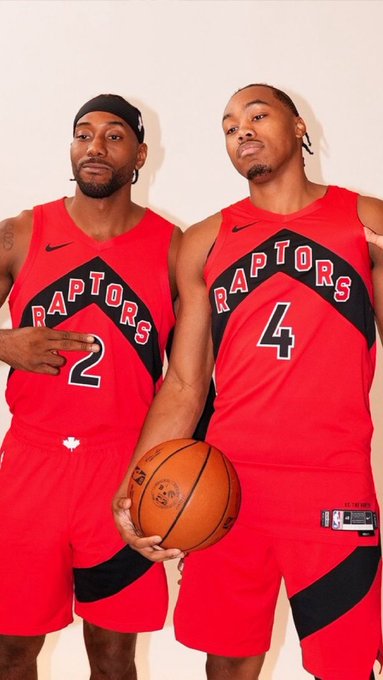 Two Toronto Raptors players pose together in their red "RAPTORS" jerseys, with the player on the right wearing #4 holding a basketball. The image relates to the post about the Raptors' projected starting lineup, visually showcasing two of its key members—likely RJ Barrett (#9) and Scottie Barnes (#4)—in their team uniforms as the franchise builds toward a promising playoff run.