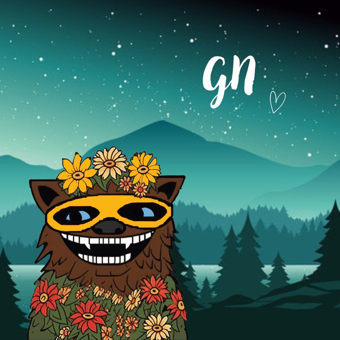 A whimsical illustration features a grinning brown bear character adorned with a yellow flower crown of sunflowers and wearing a yellow superhero mask, surrounded by vibrant wildflowers against a serene night scene of mountains and evergreen trees under a starry teal sky, with the handwritten white text "GN" and a small heart in the upper right—perfectly complementing the post's sweet "goodnight" wish.