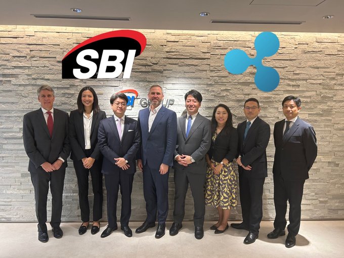 Executives from SBI Group and Ripple pose together in front of their company logos, highlighting their partnership in bringing XRP adoption to Japan, with Ondo also noted as a Ripple partner in the accompanying post.
