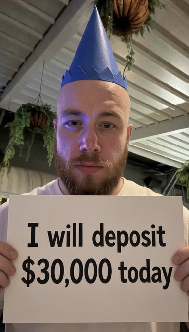 A bald man with a beard wears a blue party hat and holds a sign reading "I will deposit $30,000 today," celebrating his 30th birthday with a $30K Roobet deposit announcement.