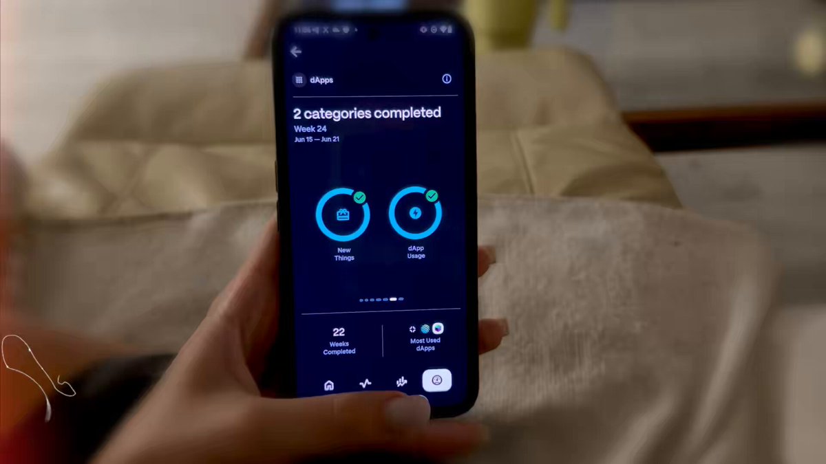The image shows a person holding up their phone displaying the progress of two categories completed, with a total of 2 out of 3 categories finished. The person's hand is visible above the phone screen as they show off their accomplishment.