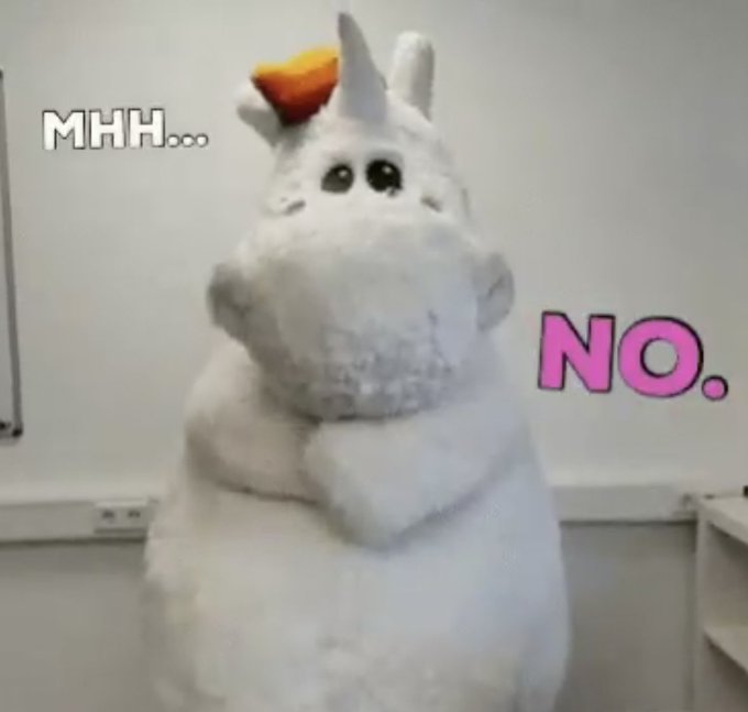 A person wearing a fluffy white unicorn costume stands in an indoor setting with the text "MHH..." in white on the upper left and "NO." in large pink letters on the right side.