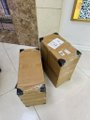 Two small brown cardboard boxes sitting on a tiled floor next to a rug.