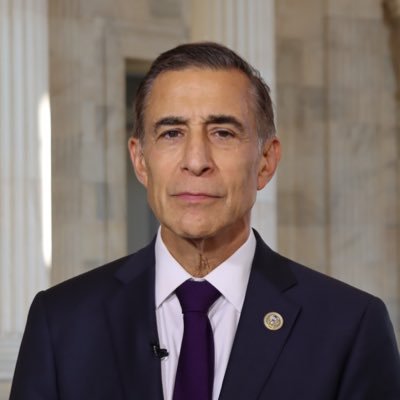 A man in a dark suit and purple tie stands in what appears to be a formal government building with marble columns, presumably Rep. Darrell Issa who has introduced new legislation to require federal agencies to secure cryptocurrency and digital assets found in seized electronic devices.