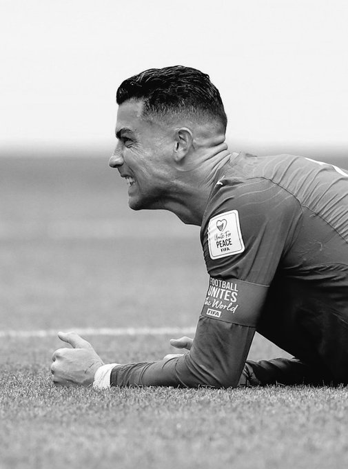 The image features a soccer player, likely Lionel Messi, lying down on the grass with his arms outstretched. The photo has been edited to appear black and white, giving it an artistic touch. The caption of the image reads "Everyone who bet portugal to win comfortably yesterday is currently staring at their @polymarket portfolio like it owes them an explanation ... who's the goat again? Yes." This suggests that the soccer player might be a subject of interest for some people or that they are discussing the player in question.