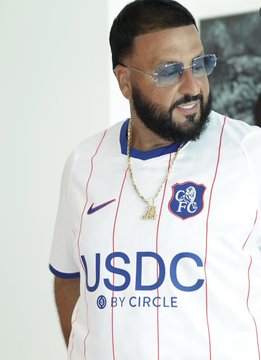 A bearded man wearing sunglasses poses in a white Chelsea FC kit featuring the "USDC by CIRCLE" sponsor logo, which nods to the post's exclamatory "waaaat" reaction likely sparked by the unexpected cryptocurrency sponsor on the Premier League jersey.