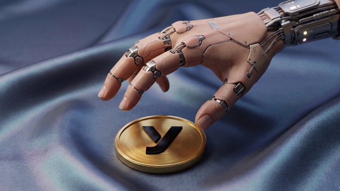 The image features a hand reaching out towards a gold coin with the letter "Y" written on it. The hand appears to be touching or about to touch the coin, which is placed on top of a blue cloth. The background of the image is dark, making the gold coin stand out prominently against the backdrop.