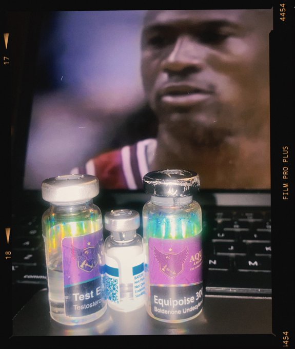 Three vials of performance-enhancing substances—Test E (Testosterone Enanthate), GH (Growth Hormone), and Equipoise (Boldenone Undecylenate)—sit on a laptop displaying a 1996 Bulls poster, aligning with the post's "Test E GH EQ 96 Bulls Type" stack reference.