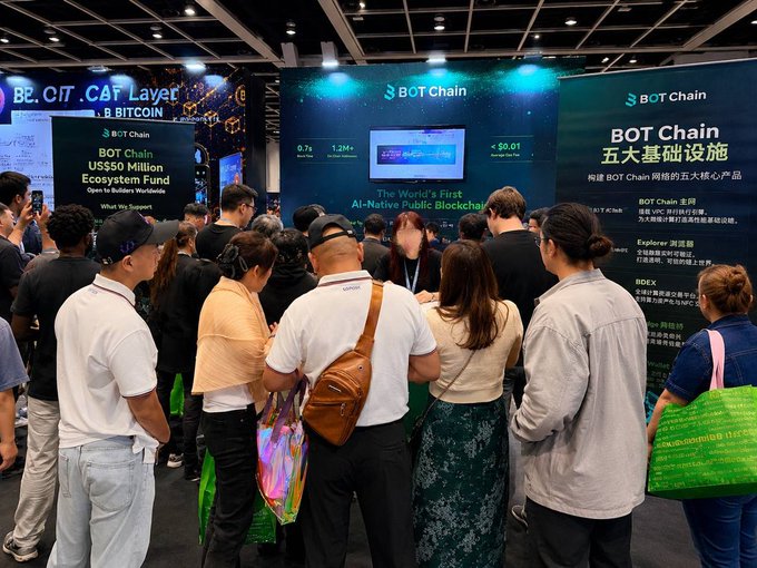 A crowd gathers at a BITCOIN/BOT Chain expo booth promoting 'BOT Chain US$50 Million Ecosystem Fund' and 'The World's First AI-Native Public Blockchain,' with Chinese text highlighting infrastructure facilities.