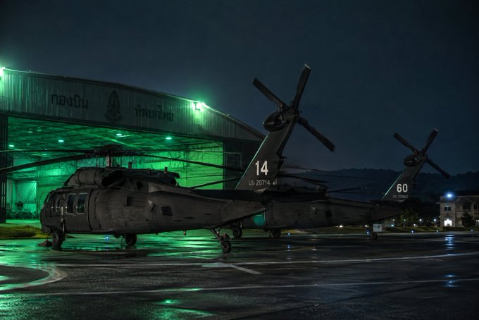 Two US Army helicopters, one marked "14 US 20714" and the other "60 US 22840", are parked outside a hangar at night. The image likely represents the "Hunting Time" the post refers to, with the helicopters potentially being clues or part of the narrative.