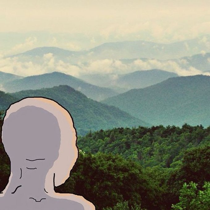A cartoonish gray figure with a blank face is superimposed over a scenic view of the Blue Ridge Mountains, creating a surreal contrast. The image relates to the post by symbolizing an optimistic, bullishly-gazing figure contemplating market positions against a backdrop of vast, layered mountain ranges.