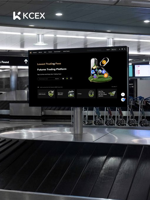 KCEX cryptocurrency exchange billboard displayed at an airport baggage claim area, advertising 'Lowest Trading Fees' on a Futures Trading Platform.