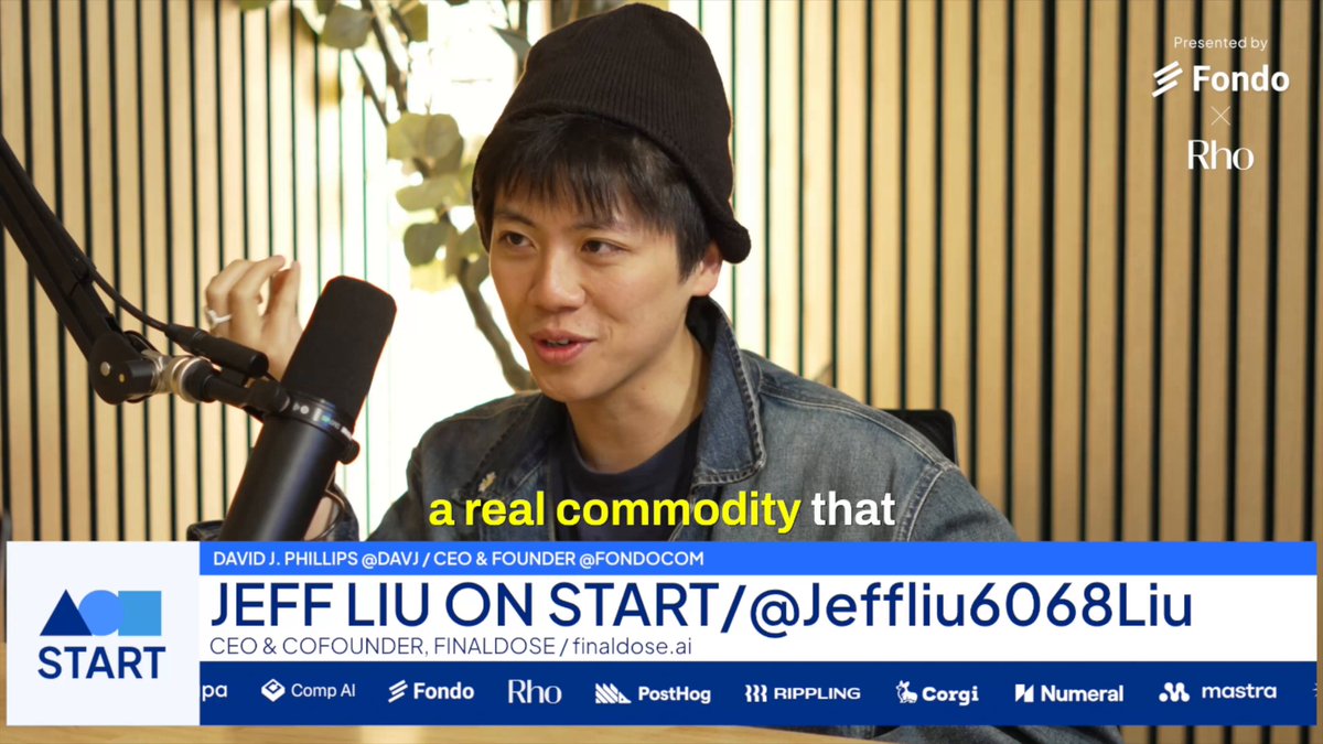 The image shows a man wearing a beanie hat, sitting at a desk holding a microphone. The background of the image features a wooden wall with a plant behind him. There are also other text elements present in the image that read "Start", "@OpenAI", and "#start". These elements suggest that this is part of an advertisement or promotional material for a project called @OpenAI, which is focused on creating artificial intelligence systems. The man holding the microphone appears to be talking about the project, possibly discussing its benefits or sharing his thoughts on it.