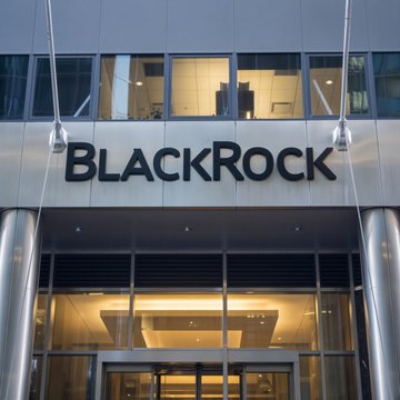The image shows the entrance of a BlackRock office building, with the company's name prominently displayed in bold black lettering above the glass doors. The accompanying post connects to BlackRock's perspective on Bitcoin's recent decoupling from equities, as expressed by their Head of Digital Assets, Robert Mitchnick.