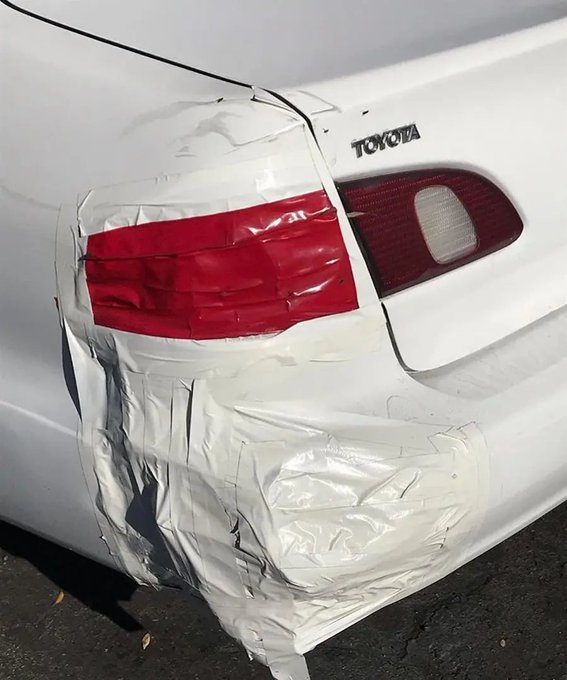 A close-up photo shows the dented rear bumper of a white Toyota, heavily covered in gray duct tape.