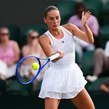 A female tennis player in a white outfit is captured mid-swing, hitting a yellow tennis ball with her racket on what appears to be a grass court, likely during Wimbledon. The image visually represents the match referenced in the caption, where a bettor wagered $670k on Marta Kostyuk to defeat Jasmine Paolini, ultimately cashing out nearly $1 million.
