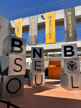 Large block letters spelling 'BNB SEOUL' are arranged outside a venue decorated with multiple yellow and black 'BNB CHAIN' banners.