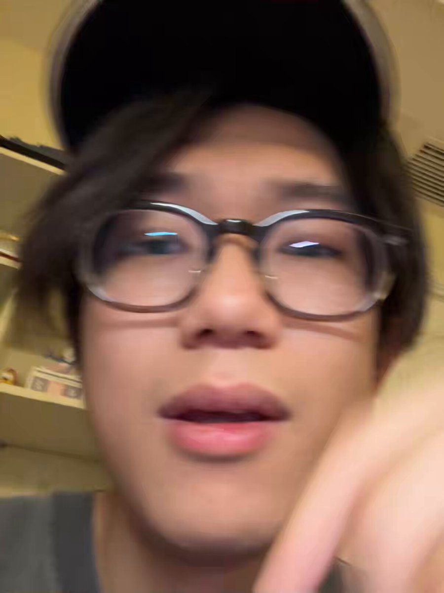 The image features a man wearing glasses with his face partially visible as he points at something or someone. The caption of the image reads "Now I want to ask two more questions. First, if @Polymarket believed the market needed clarification, why did it wait several hours after the issue had already exploded instead of clarifying immediately? Second, Polymarket said the order book after 1 PM would be cleared". This suggests that there might have been a disagreement or misunderstanding between the man and someone else regarding the stock market, and they are now waiting for further information.